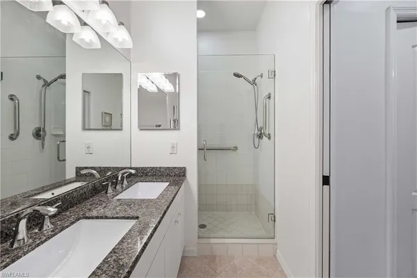 a bathroom with a granite countertop sink a mirror and a shower