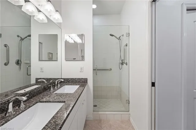 a bathroom with a granite countertop sink a mirror and a shower