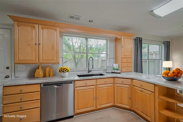 a kitchen with stainless steel appliances a sink window and cabinets
