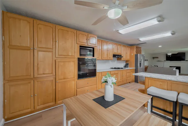 a kitchen with granite countertop white cabinets and stainless steel appliances