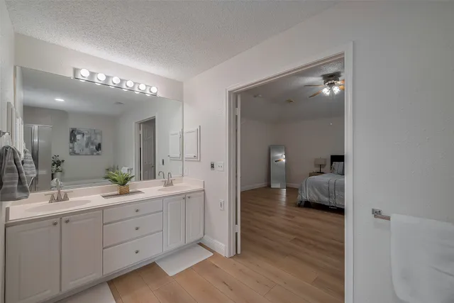 a bathroom with a double vanity sink a mirror and shower