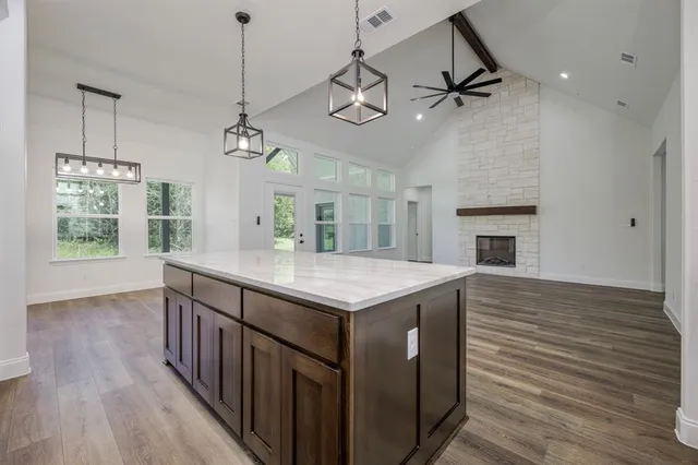 a kitchen with a stove and a wooden floor