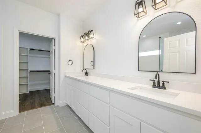 a bathroom with a double vanity sink and a mirror