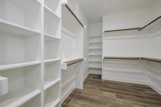 a view of walk in closet with empty racks