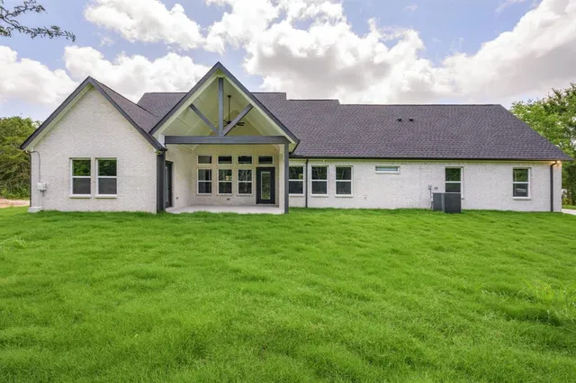 a view of a house with a yard and sitting area