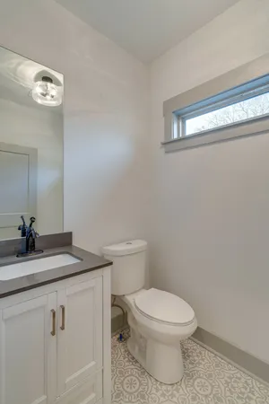 a bathroom with a granite countertop toilet sink and mirror