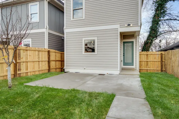 a view of backyard of house with wooden fence