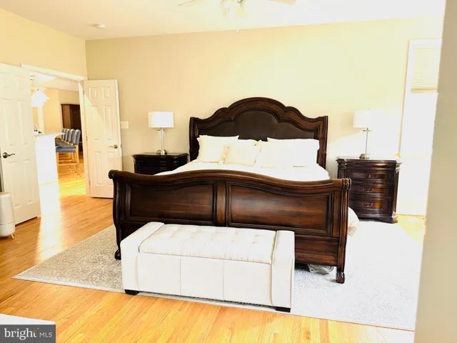 a view of an empty room with wooden floor and windows