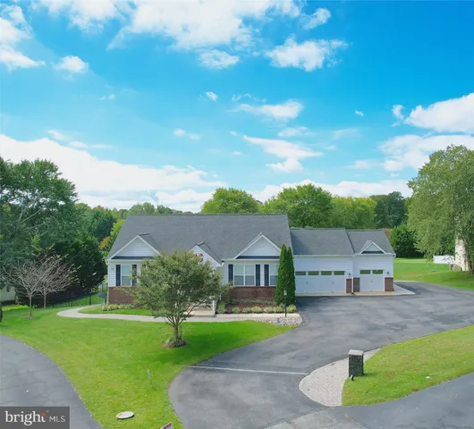 a living room with furniture kitchen view and a wooden floor