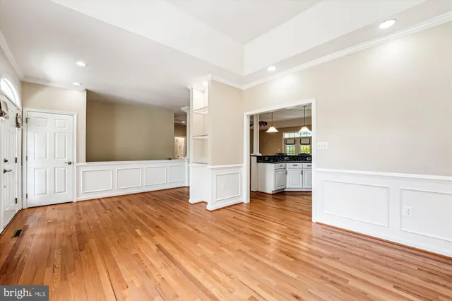 a kitchen with stainless steel appliances granite countertop a stove a sink dishwasher and a refrigerator with wooden floor