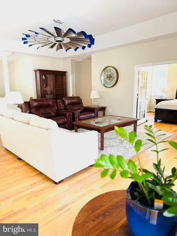 an empty room with wooden floor chandelier fan and windows