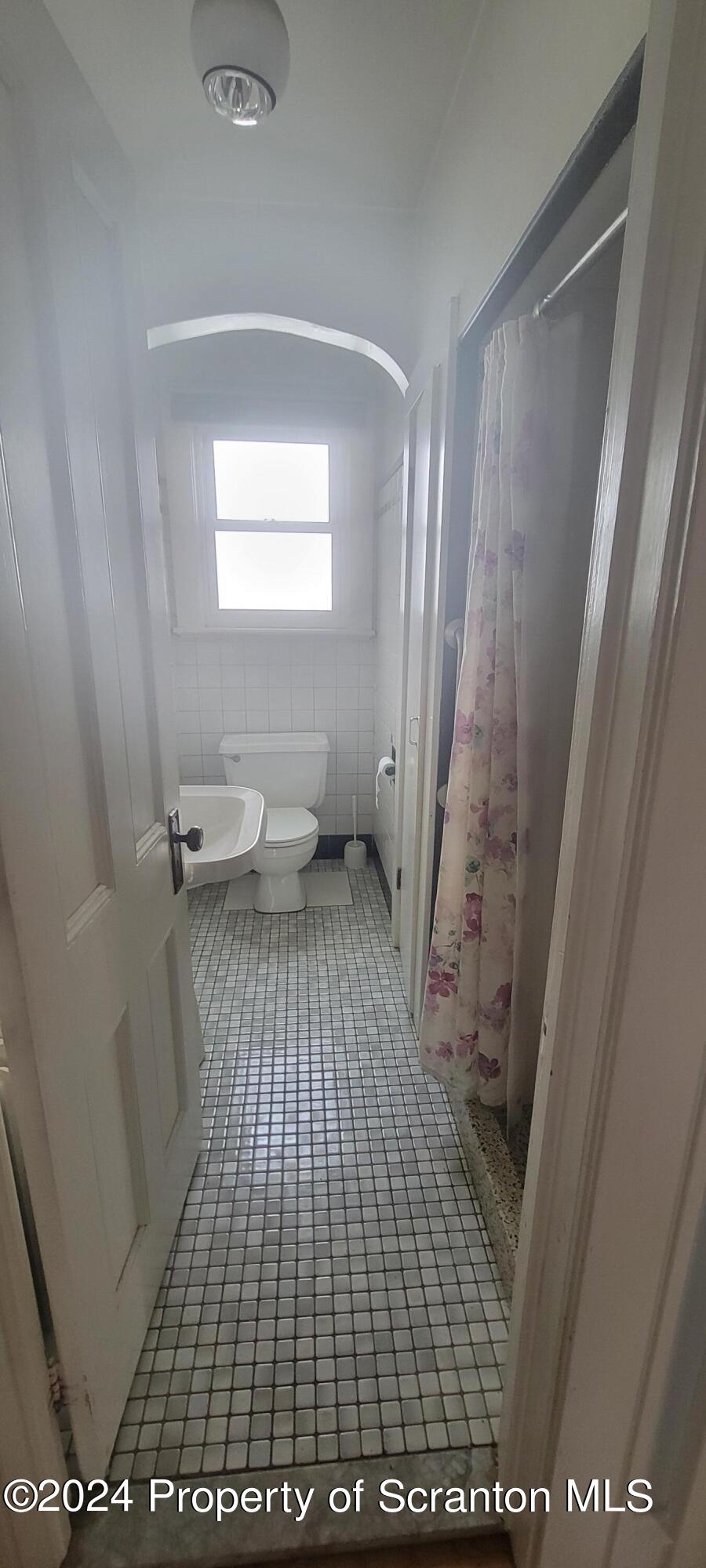 1543 Capouse Avenue Scranton, PA 18509 - Photo 11 of 62 a bathroom with a sink a toilet a window and a mirror