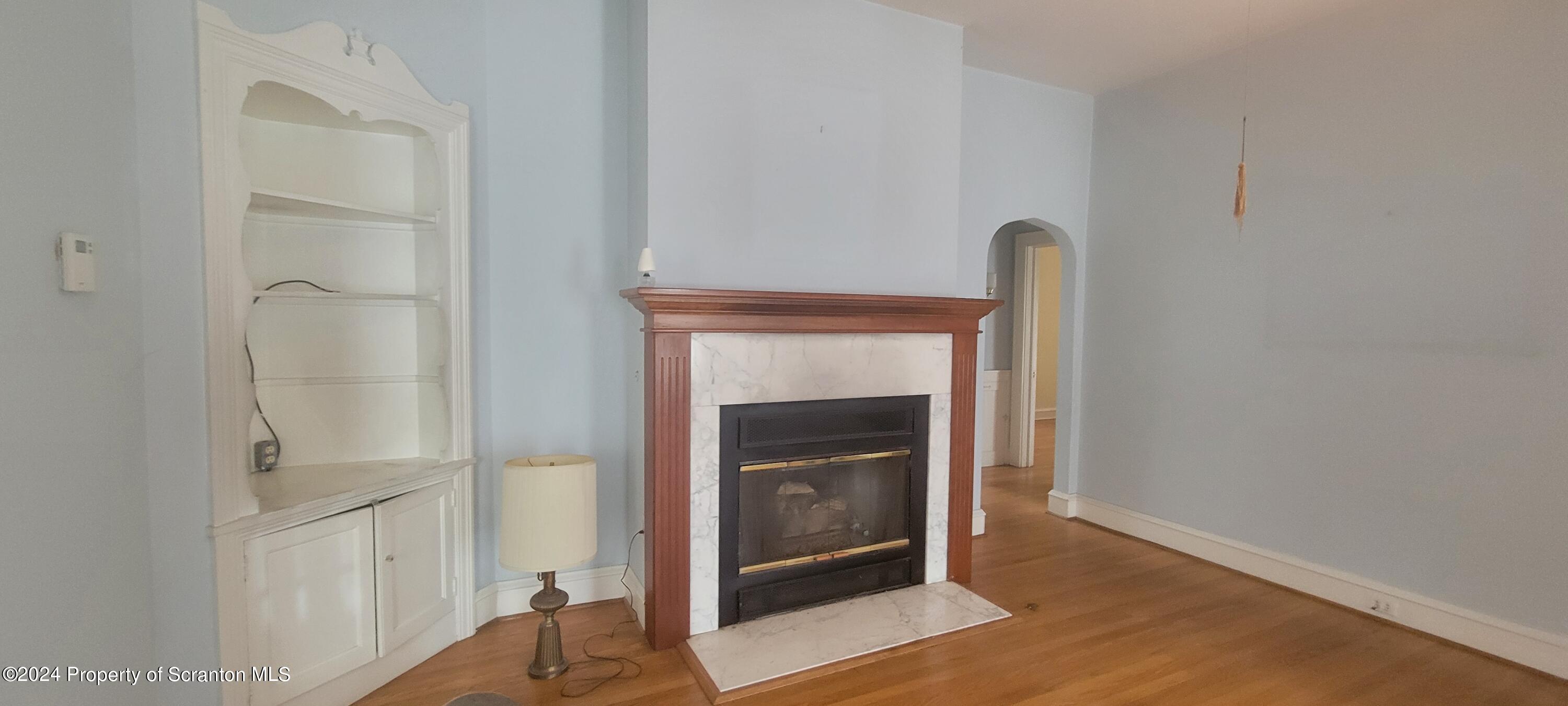 1543 Capouse Avenue Scranton, PA 18509 - Photo 15 of 62 a view of an empty room with wooden floor and a fireplace