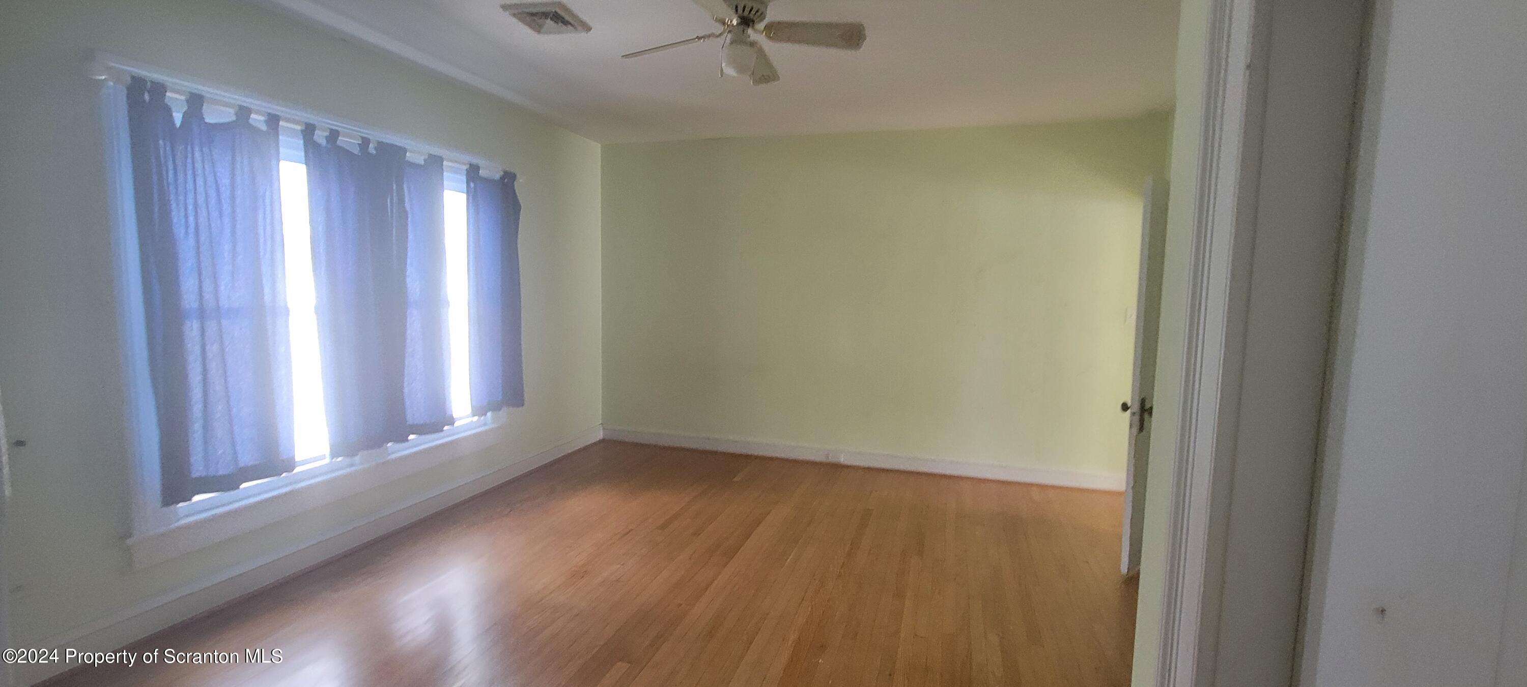 1543 Capouse Avenue Scranton, PA 18509 - Photo 35 of 62 a view of an empty room with a window and wooden floor