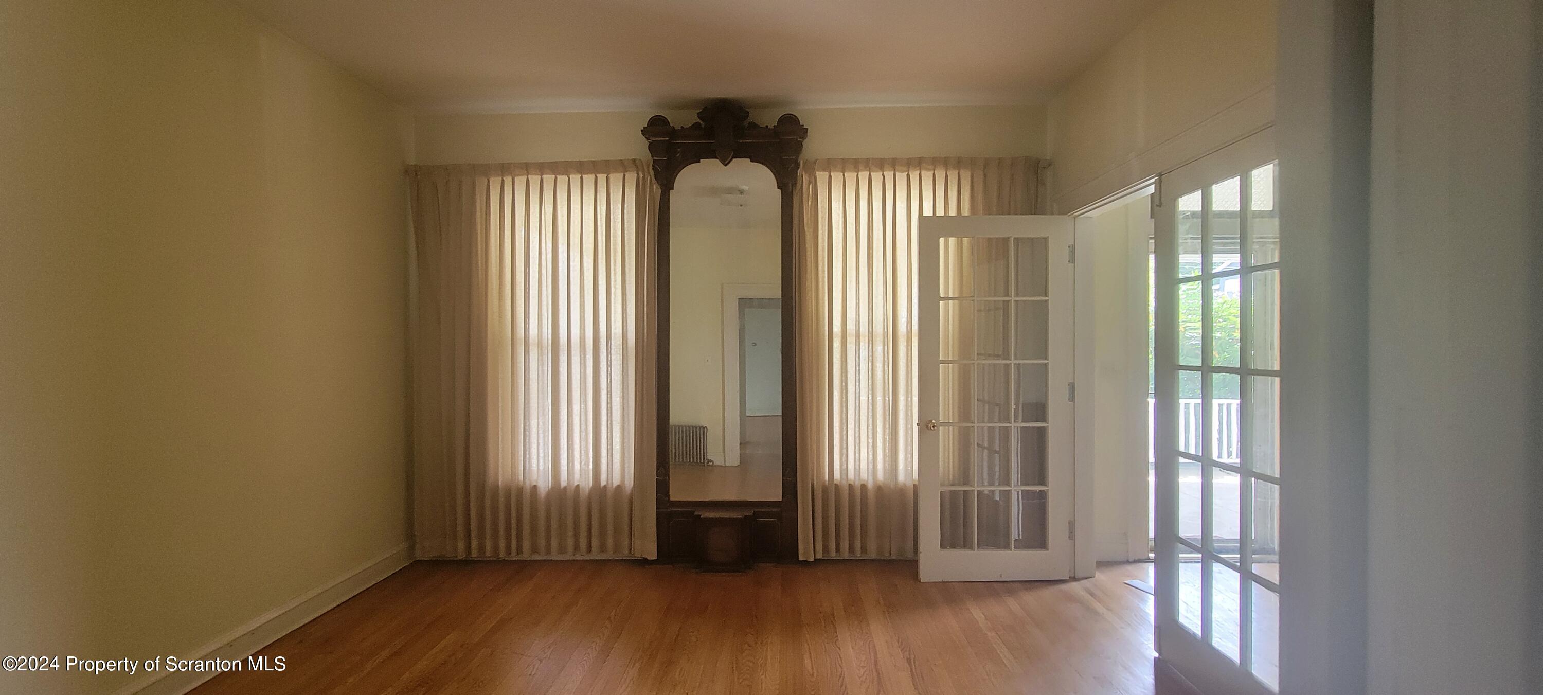 1543 Capouse Avenue Scranton, PA 18509 - Photo 9 of 62 an empty room with wooden floor and a window