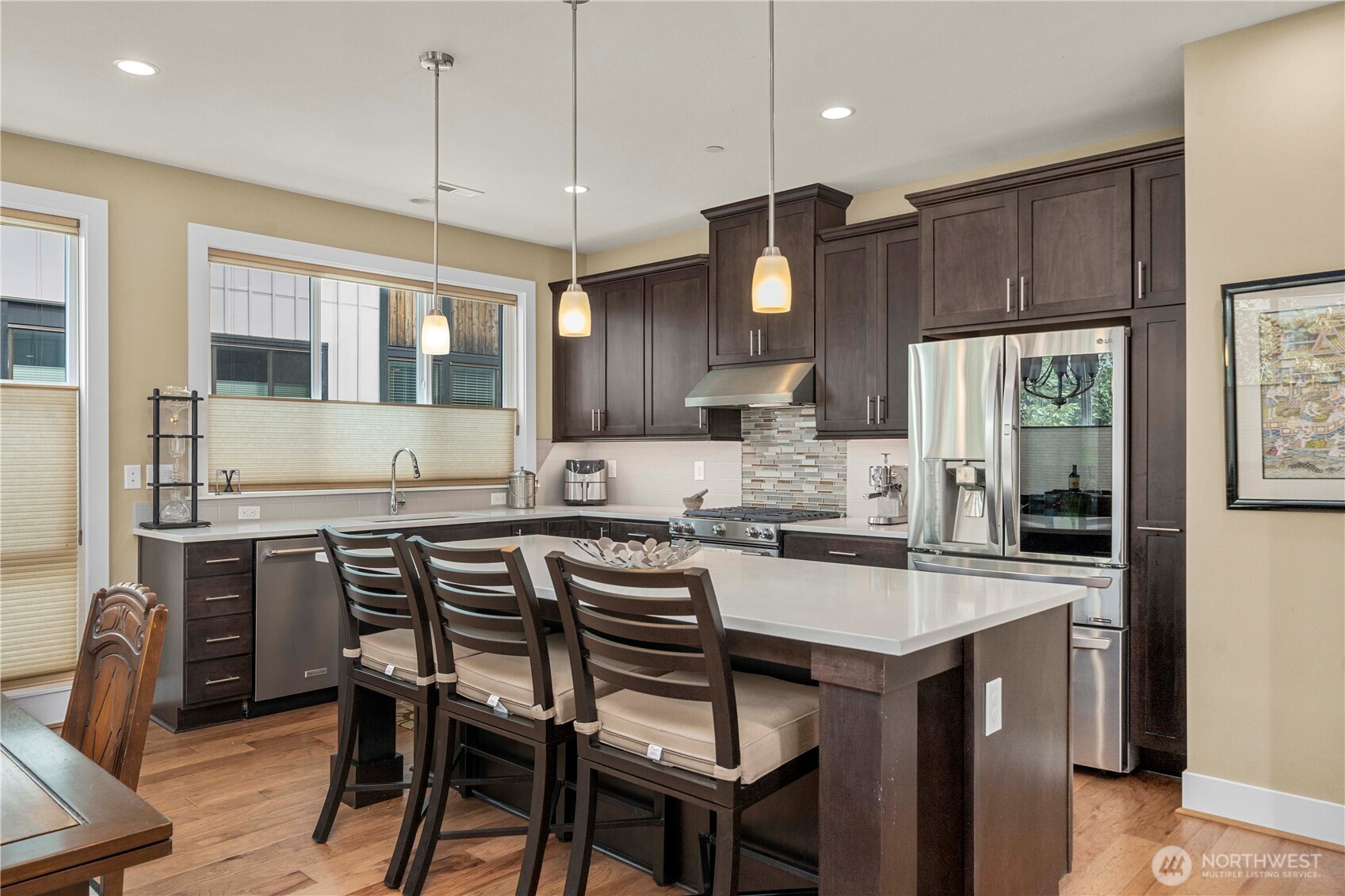 9710 Main Street, Unit A Bothell, WA 98011 - Photo 5 of 7 a kitchen with granite countertop a table chairs wooden cabinets and stainless steel appliances