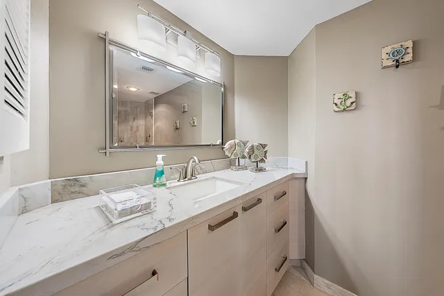 a bathroom with a granite countertop sink and a mirror