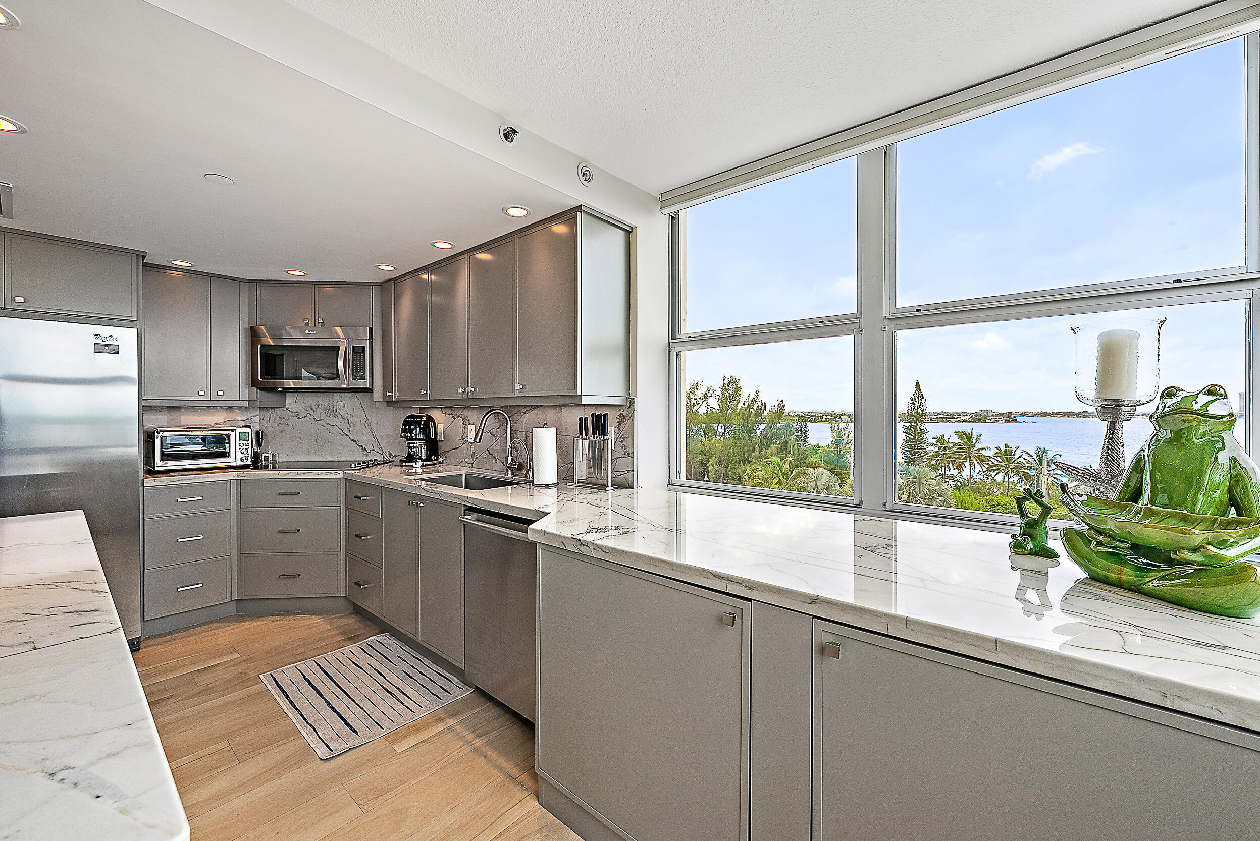 5200 North Ocean Drive, Unit 505 Singer Island, FL 33404 - Photo 8 of 30 a kitchen with a sink a counter top space stainless steel appliances cabinets and a large window