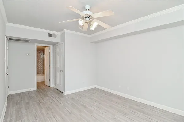 a view of an empty room with wooden floor