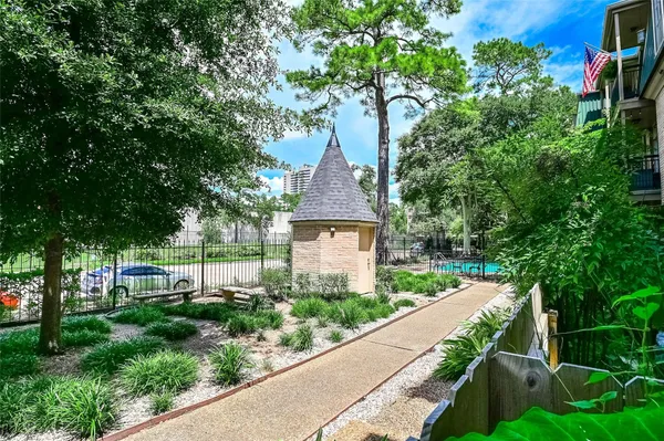 a view of a garden with large trees