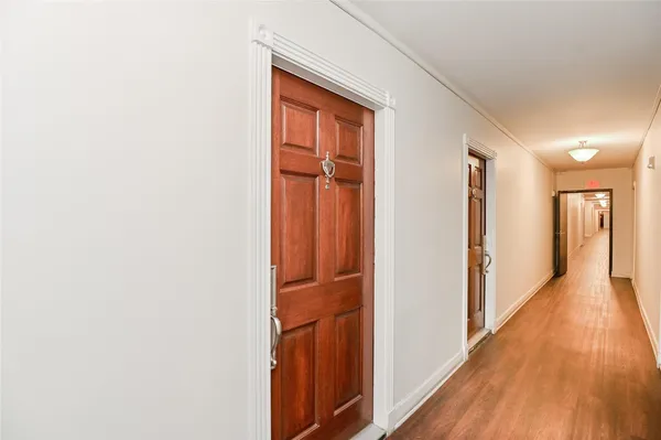 a view of a hallway with wooden floor and entryway