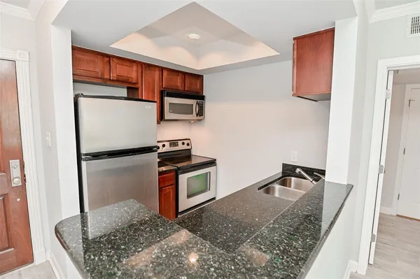 a kitchen with stainless steel appliances granite countertop a refrigerator and a sink