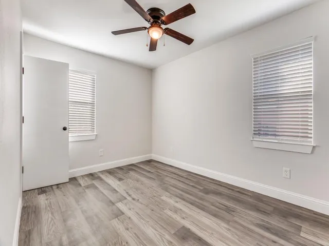 a view of a room with wooden floor and white walls