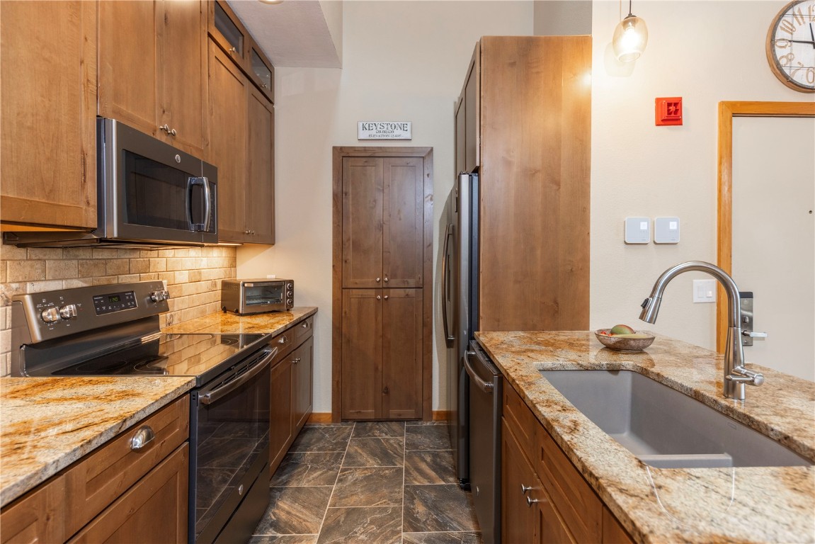 21630 Highway 6, Unit 2145 Keystone, CO 80435 - Photo 7 of 39 a kitchen with stainless steel appliances granite countertop a sink stove and refrigerator