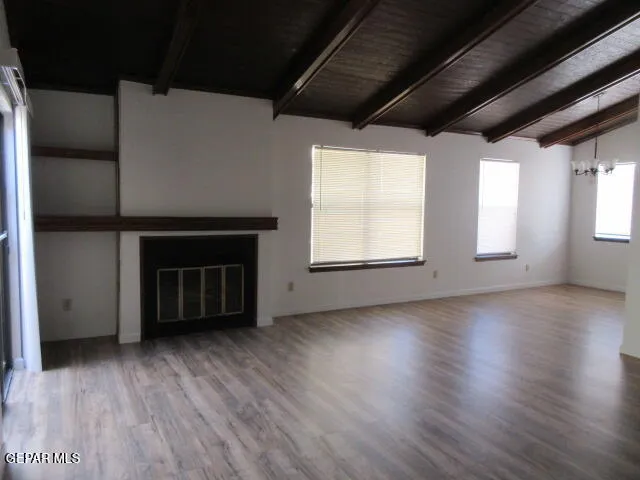 a view of empty room with wooden floor and fireplace