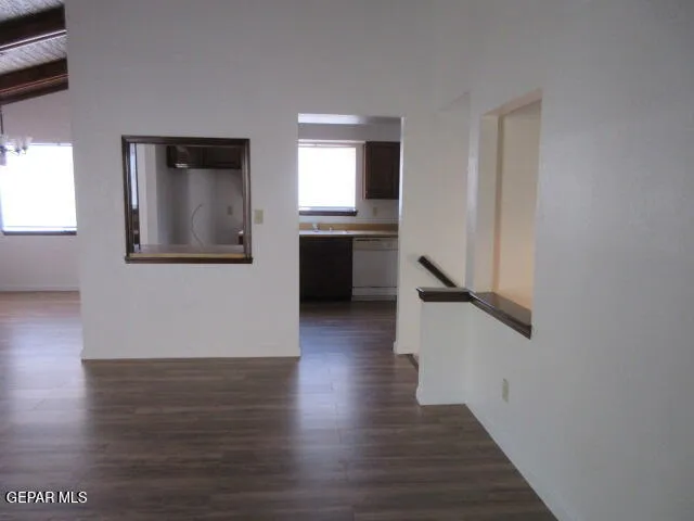 a view of a hallway with wooden floor and a kitchen