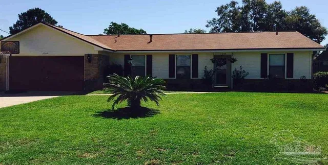 a front view of a house with a garden and plants