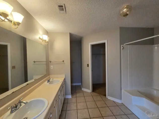 a spacious bathroom with a granite countertop sink mirror and shower