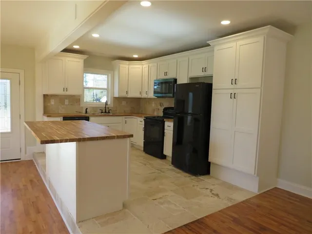 a kitchen with stainless steel appliances granite countertop a refrigerator sink and cabinets