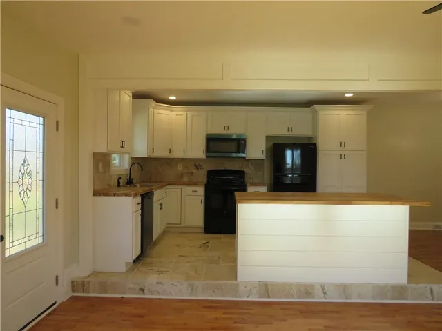 a kitchen with a refrigerator and a stove top oven