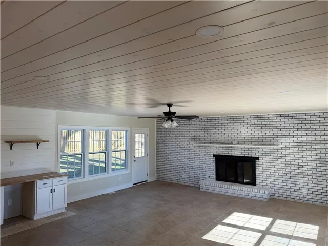 a view of a room with wooden floor and kitchen view