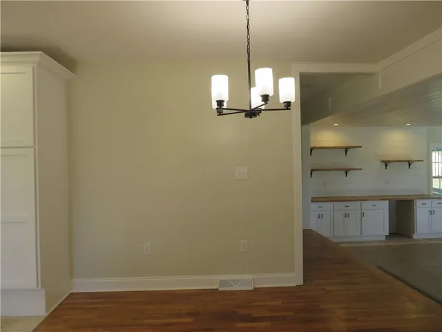 a view of a kitchen with wooden floor and a window