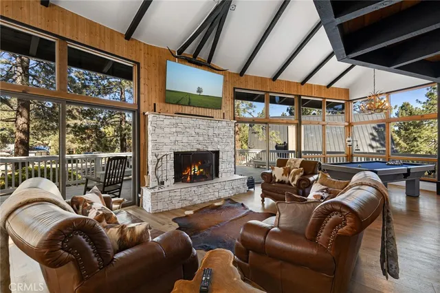 a living room with furniture a fireplace and a floor to ceiling window