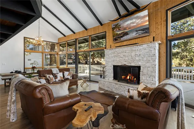 a living room with furniture a fireplace and a floor to ceiling window