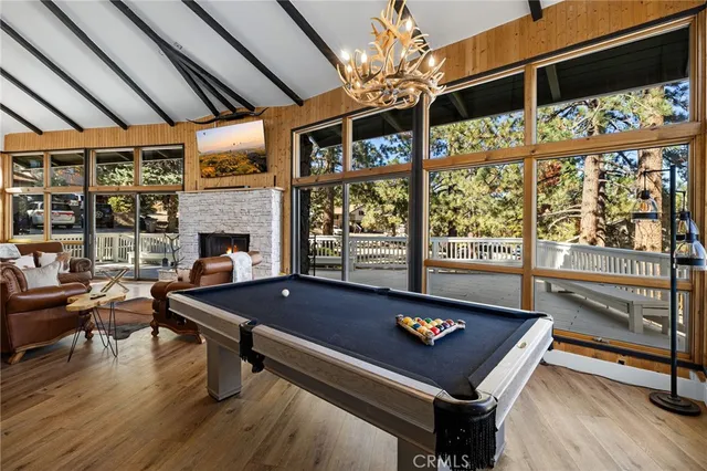 a room with furniture pool table flat screen tv and windows