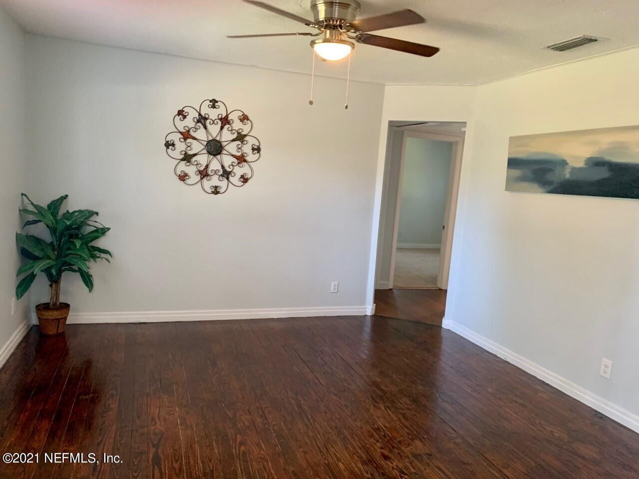 11661 Dewitt Road Jacksonville, FL 32218 - Photo 4 of 14 an empty room with wooden floor and fan