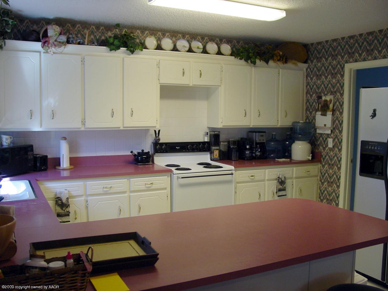 6601 Slater Circle Amarillo, TX 79110 - Photo 12 of 31 a kitchen with cabinets a stove and a kitchen island
