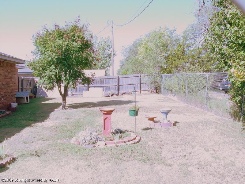 6601 Slater Circle Amarillo, TX 79110 - Photo 31 of 31 a view of a backyard with table and chairs couches under an umbrella