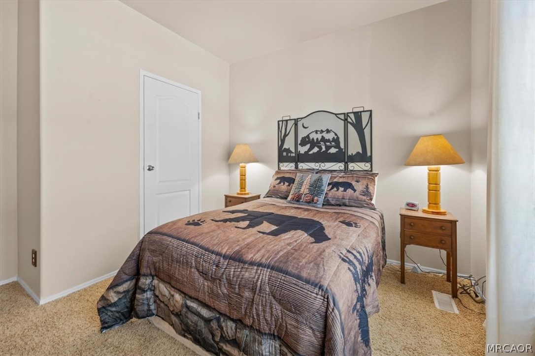 775 Riverside Avenue Sugarloaf, CA 92386 - Photo 18 of 28 a bedroom with a bed and a table in it