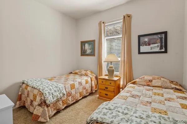 a bedroom with a bed and a lamp on the dresser