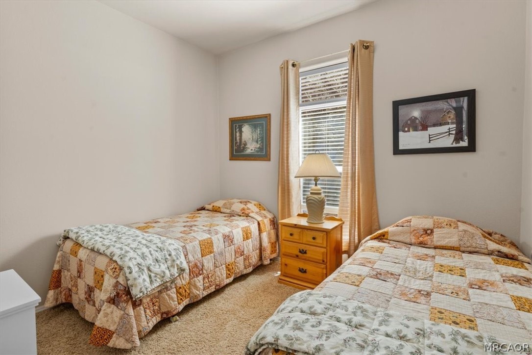 775 Riverside Avenue Sugarloaf, CA 92386 - Photo 21 of 28 a bedroom with a bed and a lamp on the dresser