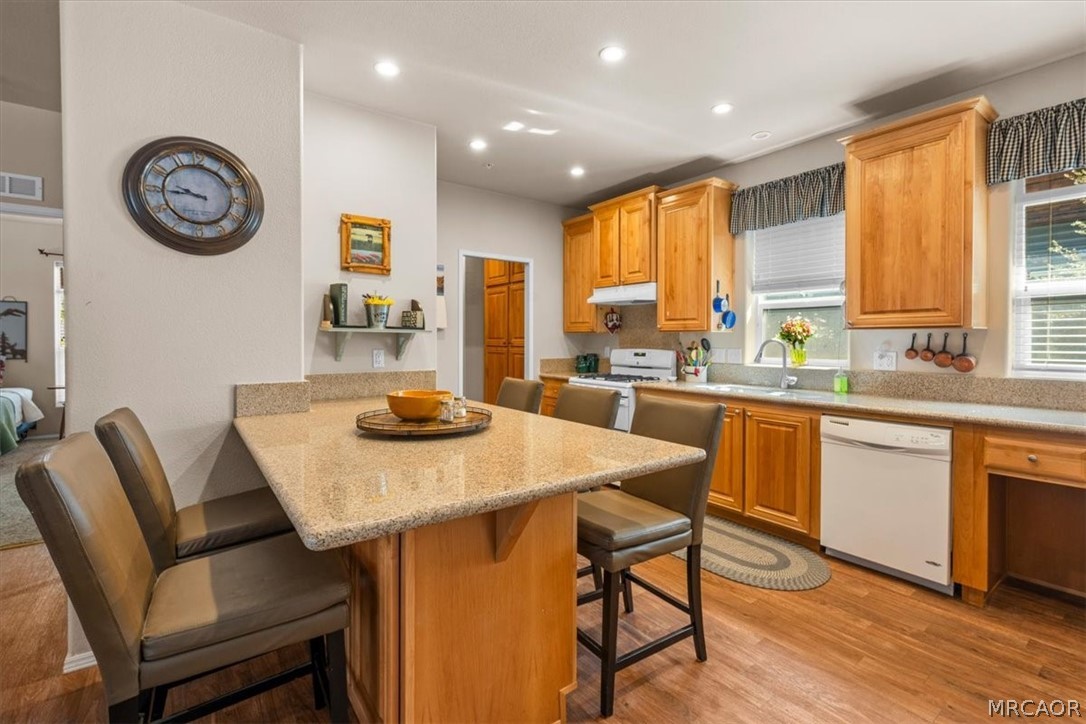 775 Riverside Avenue Sugarloaf, CA 92386 - Photo 7 of 28 a kitchen with a table chairs a stove a window and a view of living room