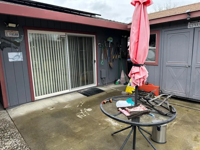 a backyard with a table and chairs and a barbeque