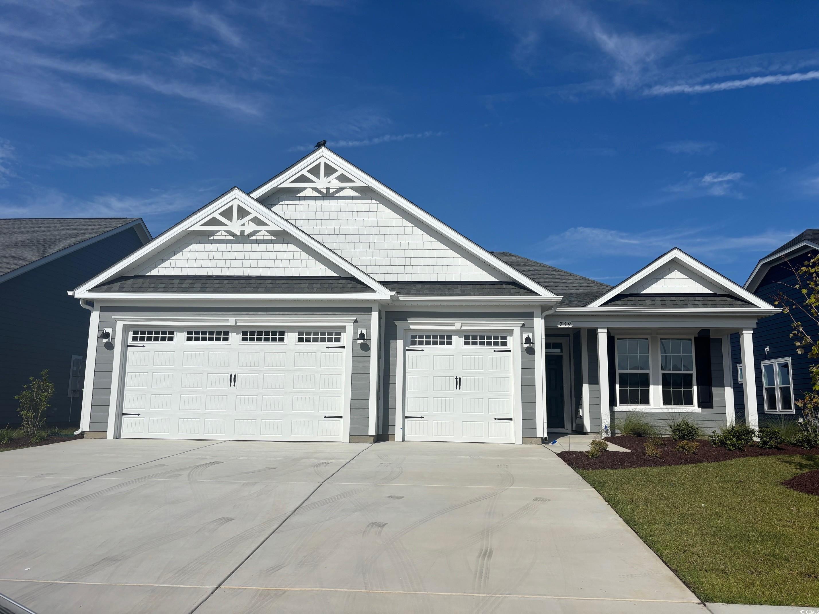 759 St Vincent Loop Little River, SC 29566 - Photo 1 of 1 View of front facade with a garage, driveway, covered porch, and a front lawn