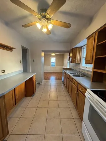 a large kitchen with kitchen island a counter space a sink and cabinets