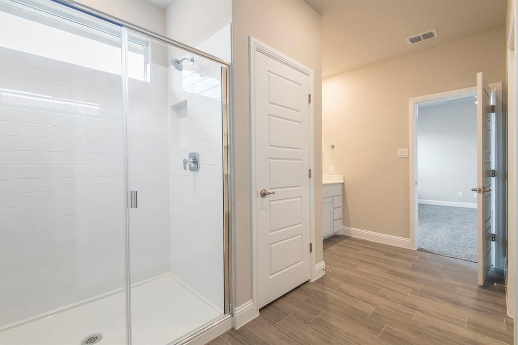2301 Ruff Road Denton, TX 76205 - Photo 14 of 23 Spacious bathroom featuring a glass-enclosed shower with subway tile surround and an integrated niche